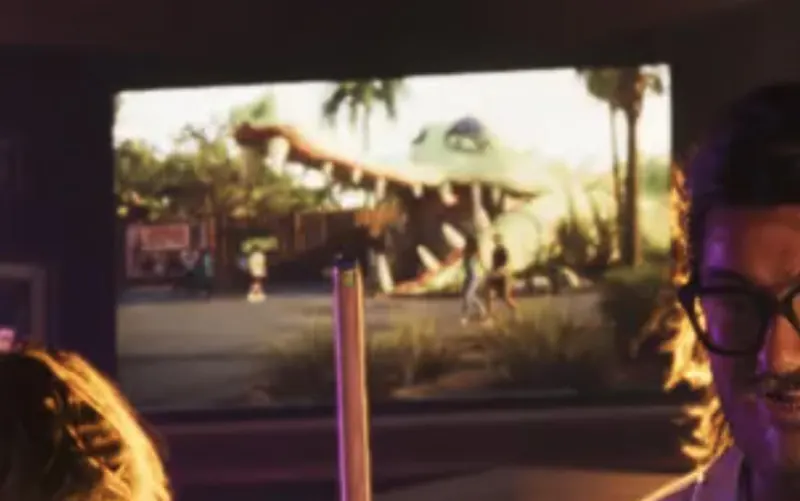 A giant alligator statue seen through a car window