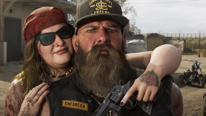 A woman in a red bandana hugs a bearded biker in an Enforcer vest holding a revolver