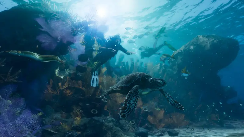 Divers swim over a coral reef next to a sea turtle