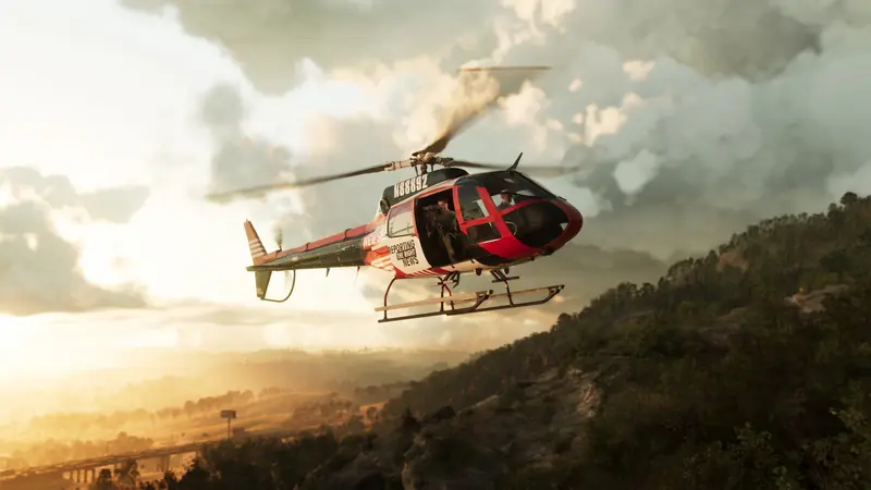 A helicopter flies low over wooded hills at sunset