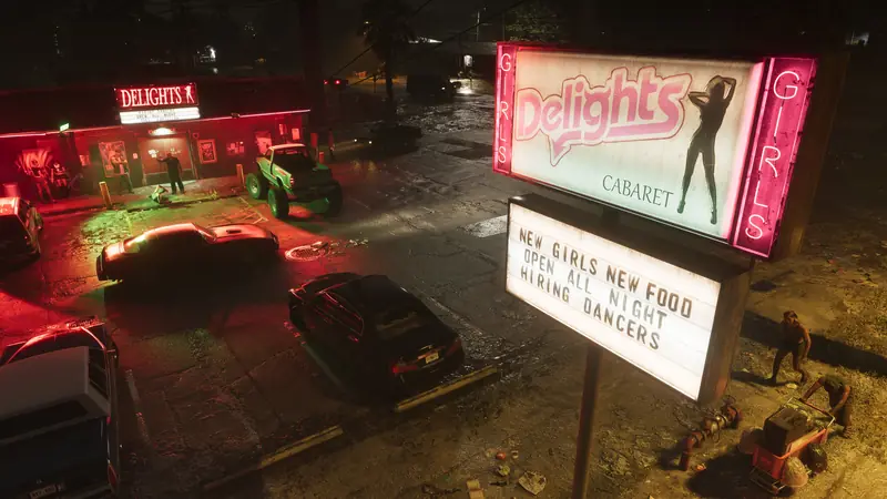 The neon sign of the Delights cabaret club lights up a parking lot at night