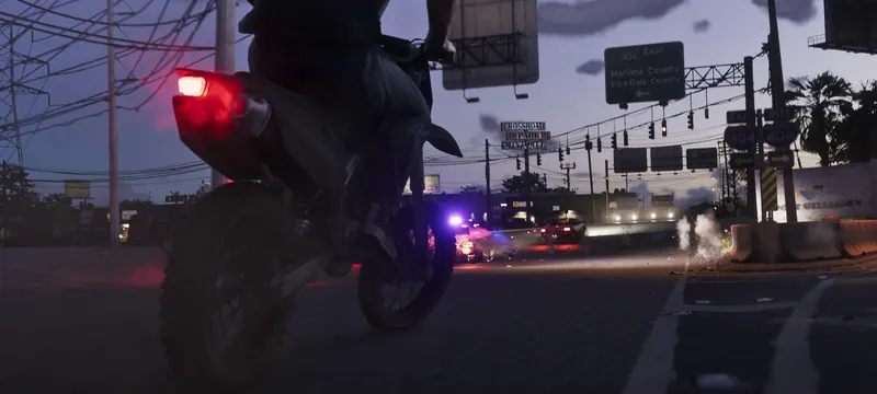 A motorcyclist rides toward a police roadblock at a Port Gellhorn intersection