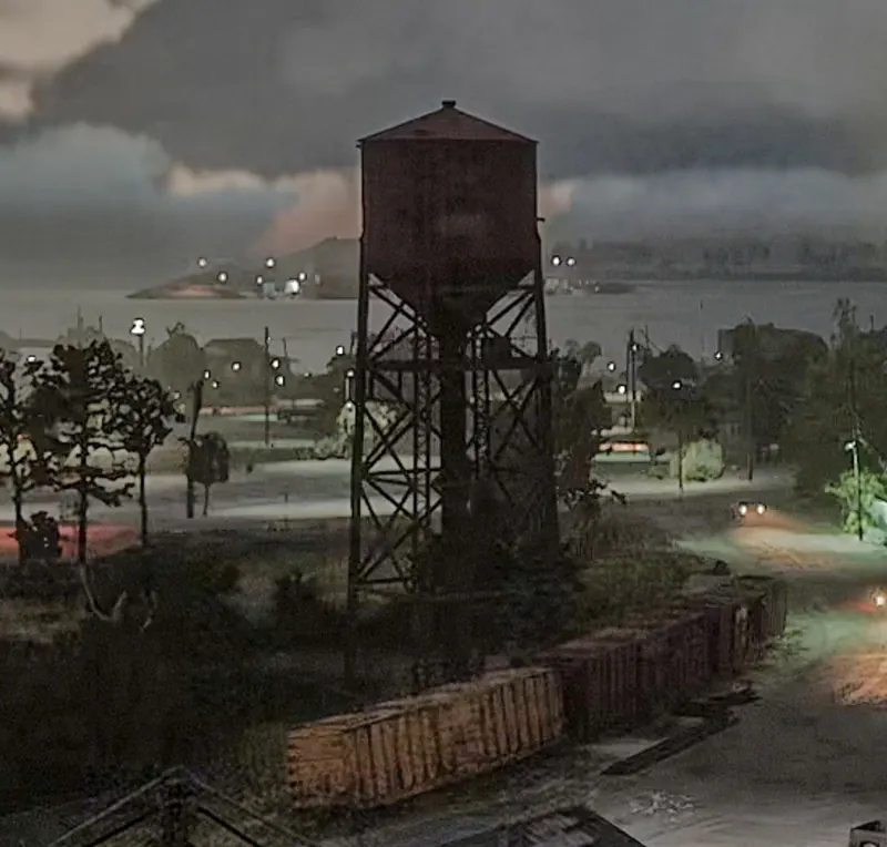 A rusty water tower above a swampy Port Gellhorn neighbourhood under storm clouds