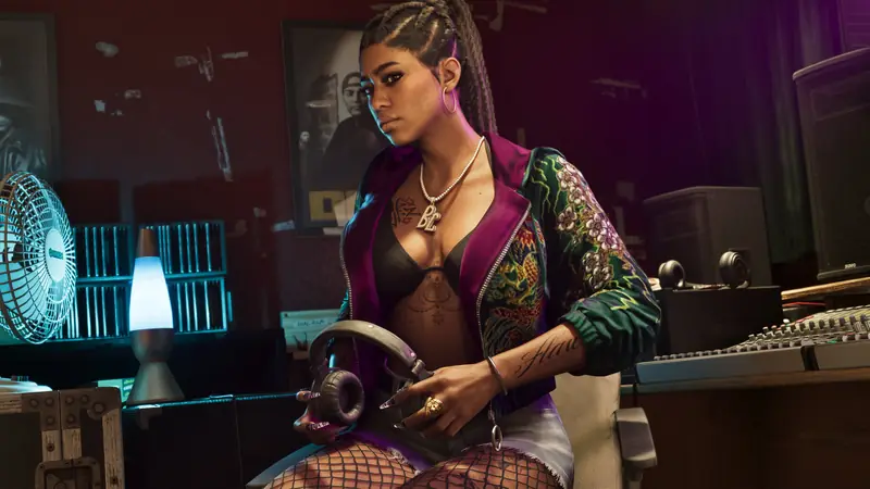 A member of Real Dimez sits at a studio desk holding headphones