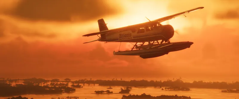 A seaplane silhouetted against an orange sunset over the islands
