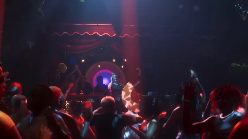 A packed nightclub dance floor under red lights in downtown Vice City
