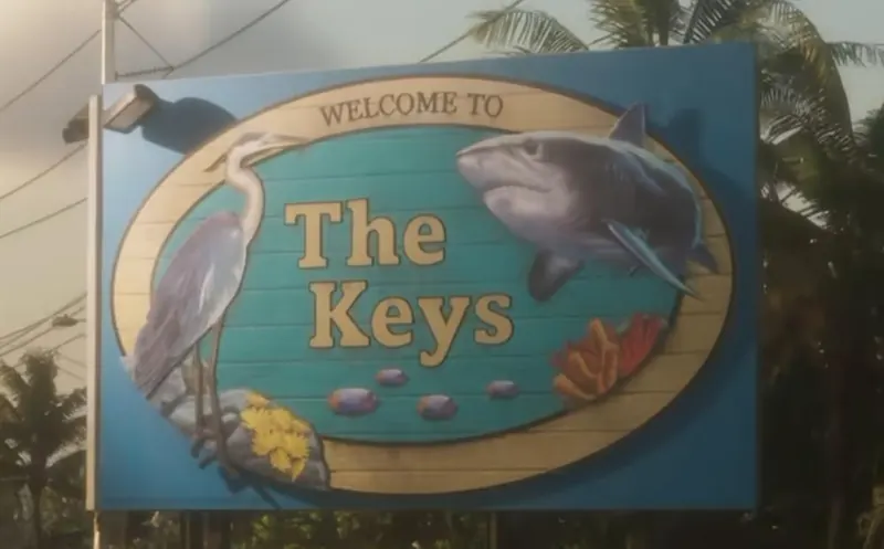 The Welcome to The Keys road sign, painted with a heron and a shark